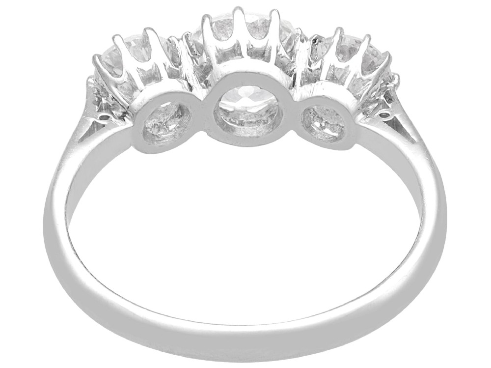 An Art Deco platinum ring set with three claw-set round diamonds positioned horizontally along the band. View VII