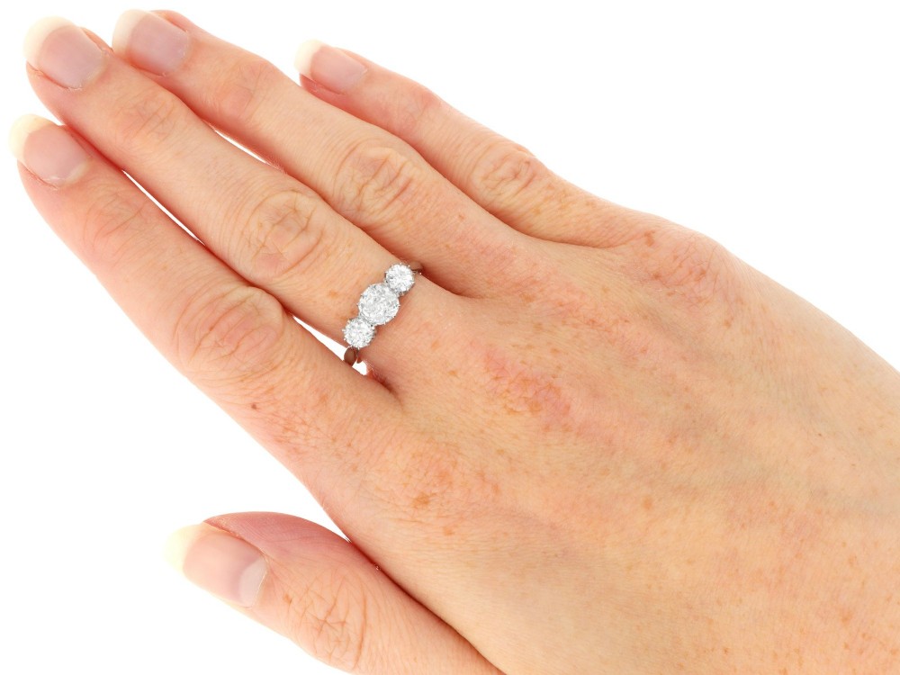 An Art Deco platinum ring set with three claw-set round diamonds positioned horizontally along the band. View IX
