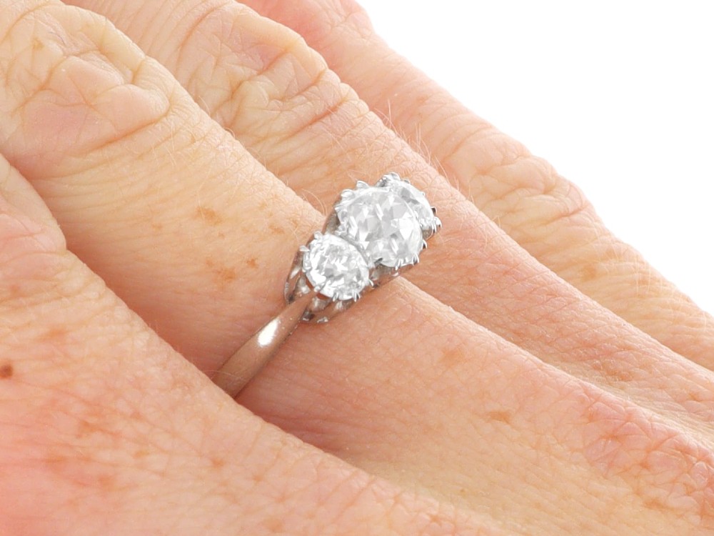 An Art Deco platinum ring set with three claw-set round diamonds positioned horizontally along the band. View X
