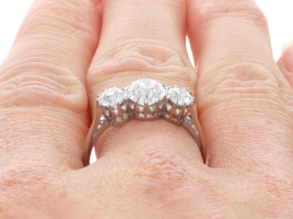 An Art Deco platinum ring set with three claw-set round diamonds positioned horizontally along the band. View XI
