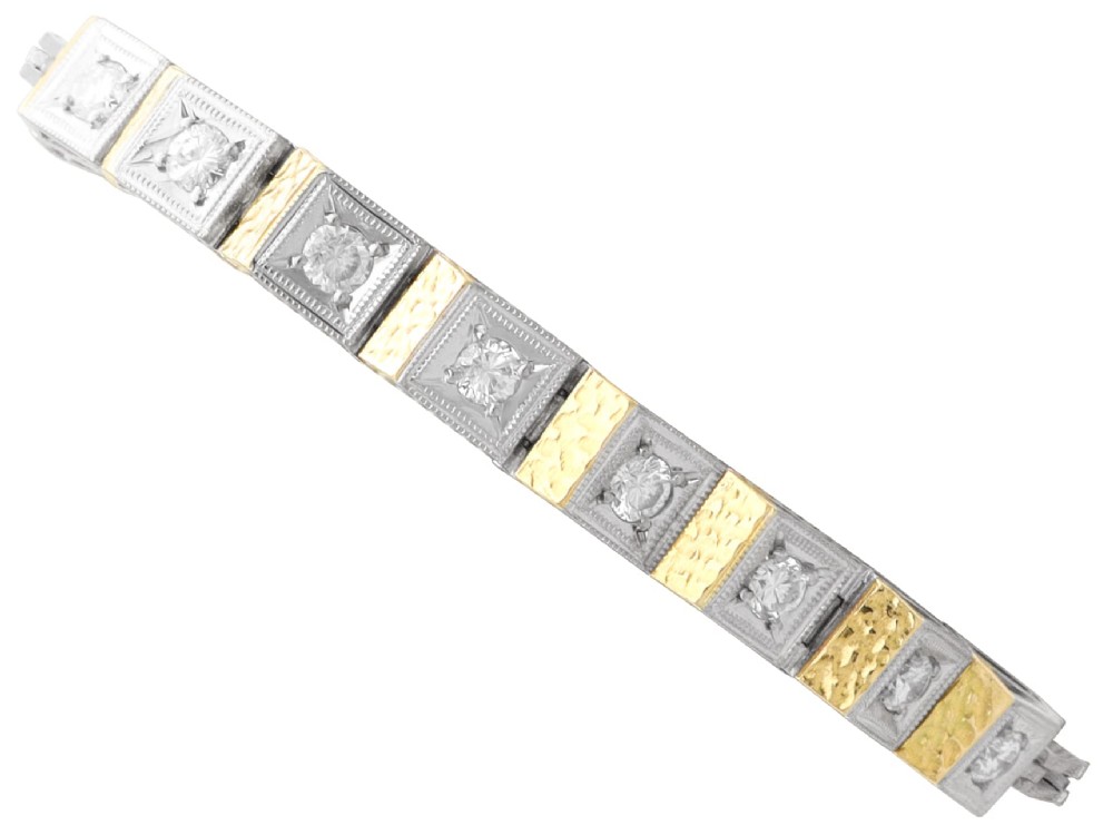 An Art Deco two-tone 18ct gold and white metal link bracelet featuring square diamond-set panels alternating with textured gold links.