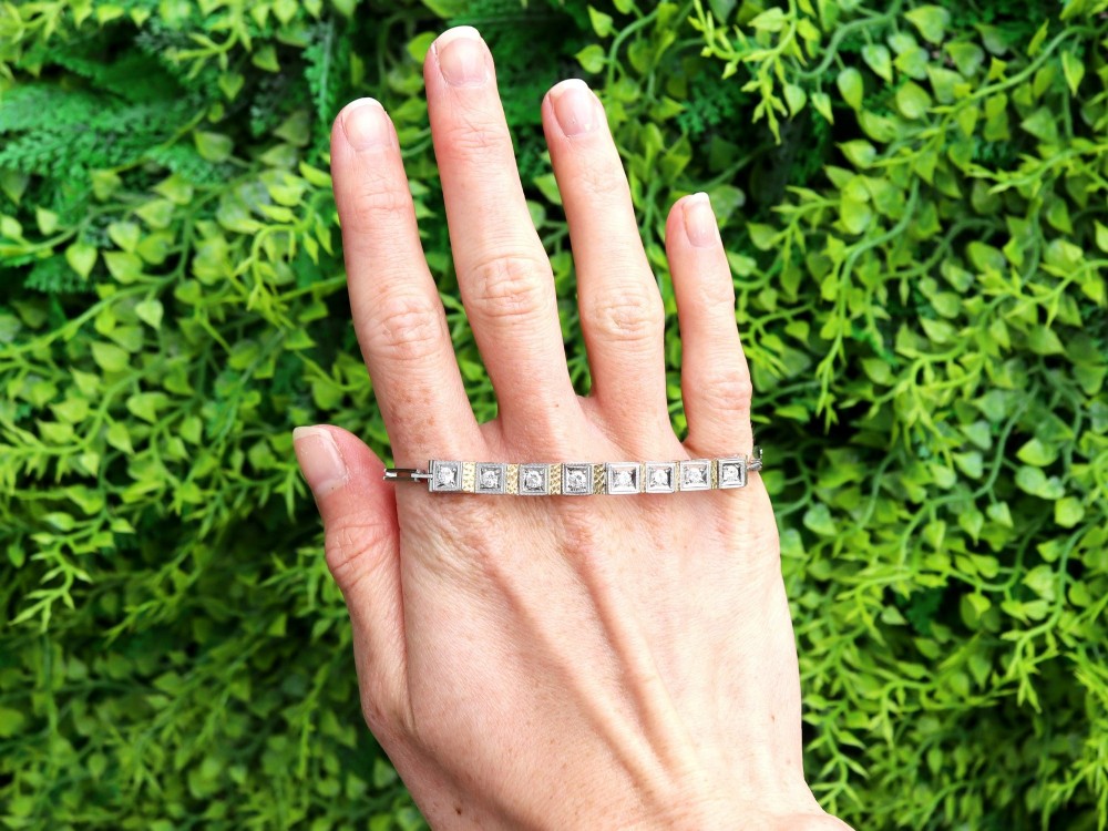 An Art Deco two-tone 18ct gold and white metal link bracelet featuring square diamond-set panels alternating with textured gold links. View II