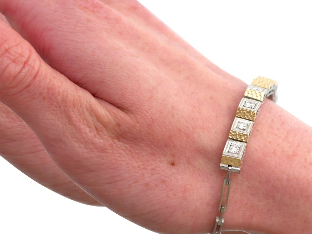 An Art Deco two-tone 18ct gold and white metal link bracelet featuring square diamond-set panels alternating with textured gold links. View XIII