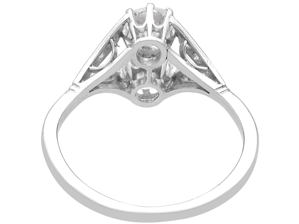 An Art Deco platinum two stone ring featuring round diamonds arranged vertically within a crossover frame with diamond-set shoulders. View VIII
