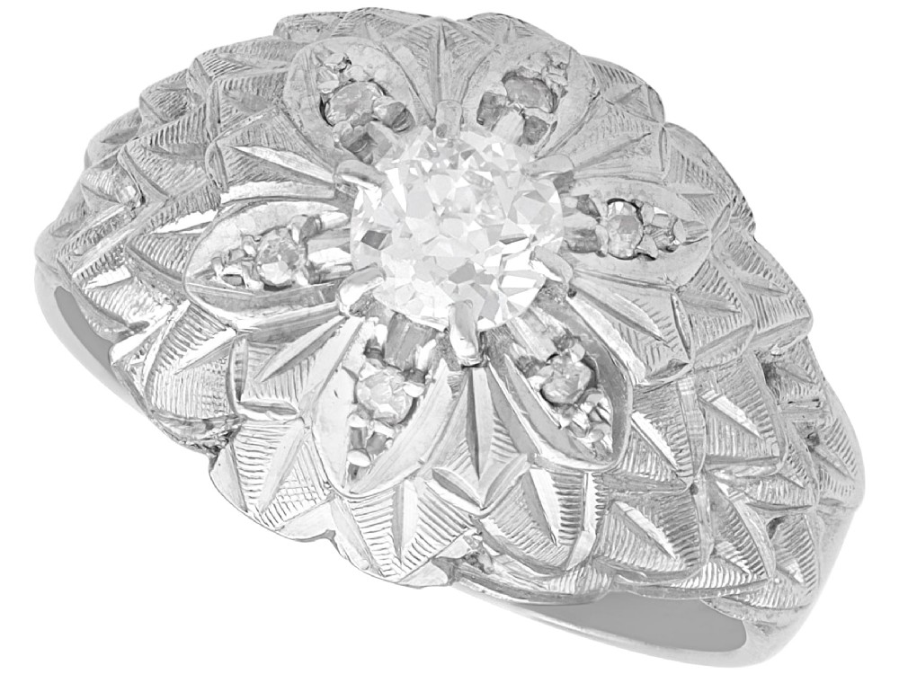 An Art Deco 18ct white gold dress ring with engraved floral textured petals and a central diamond accent.