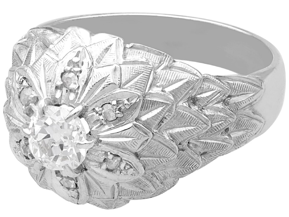 An Art Deco 18ct white gold dress ring with engraved floral textured petals and a central diamond accent. View V