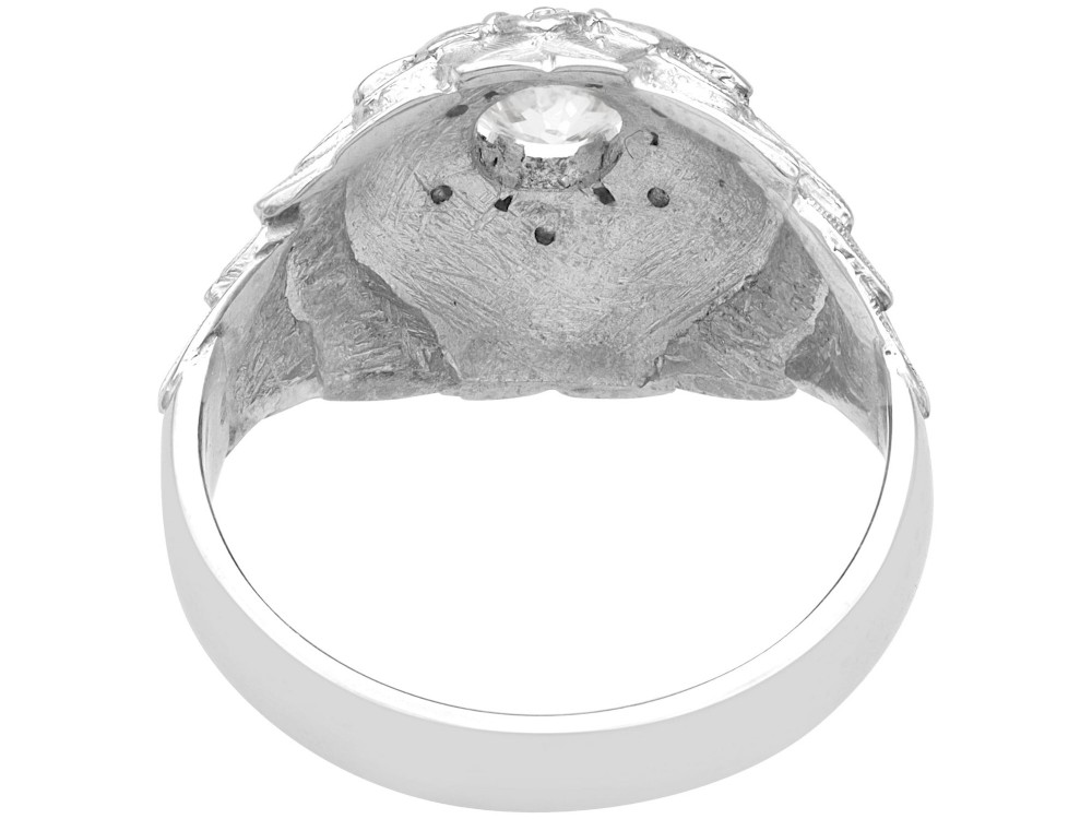 An Art Deco 18ct white gold dress ring with engraved floral textured petals and a central diamond accent. View VI