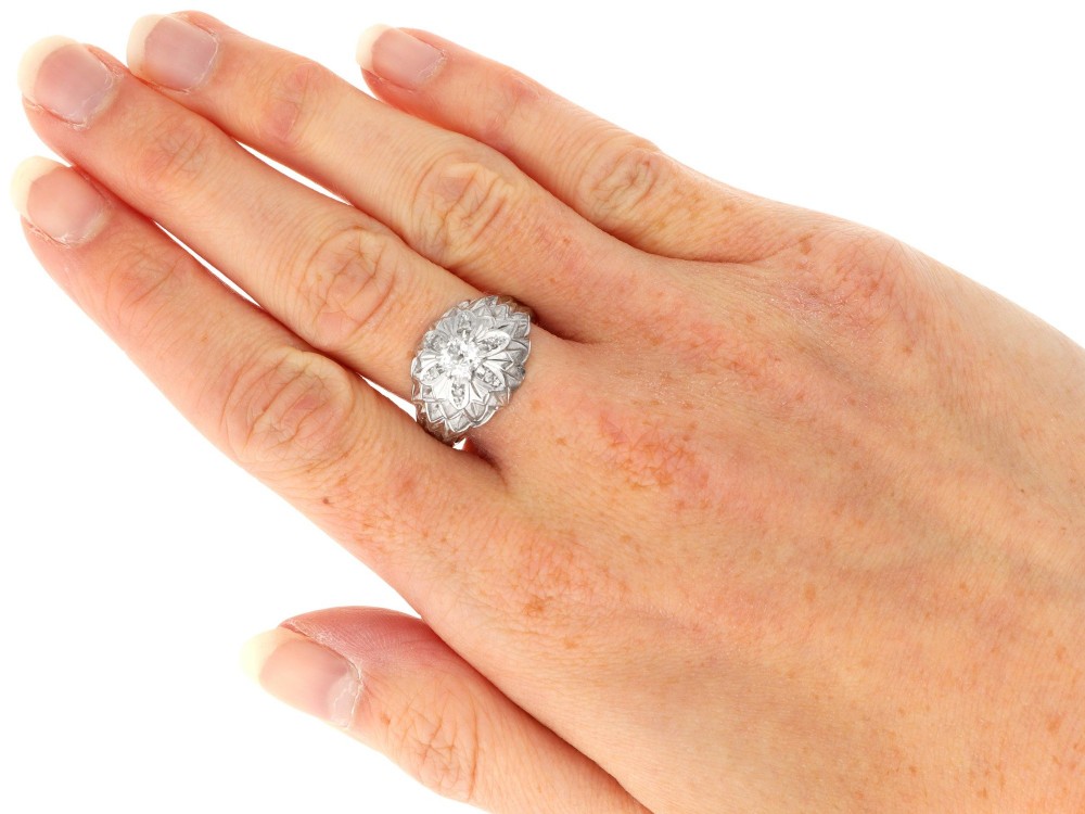 An Art Deco 18ct white gold dress ring with engraved floral textured petals and a central diamond accent. View X