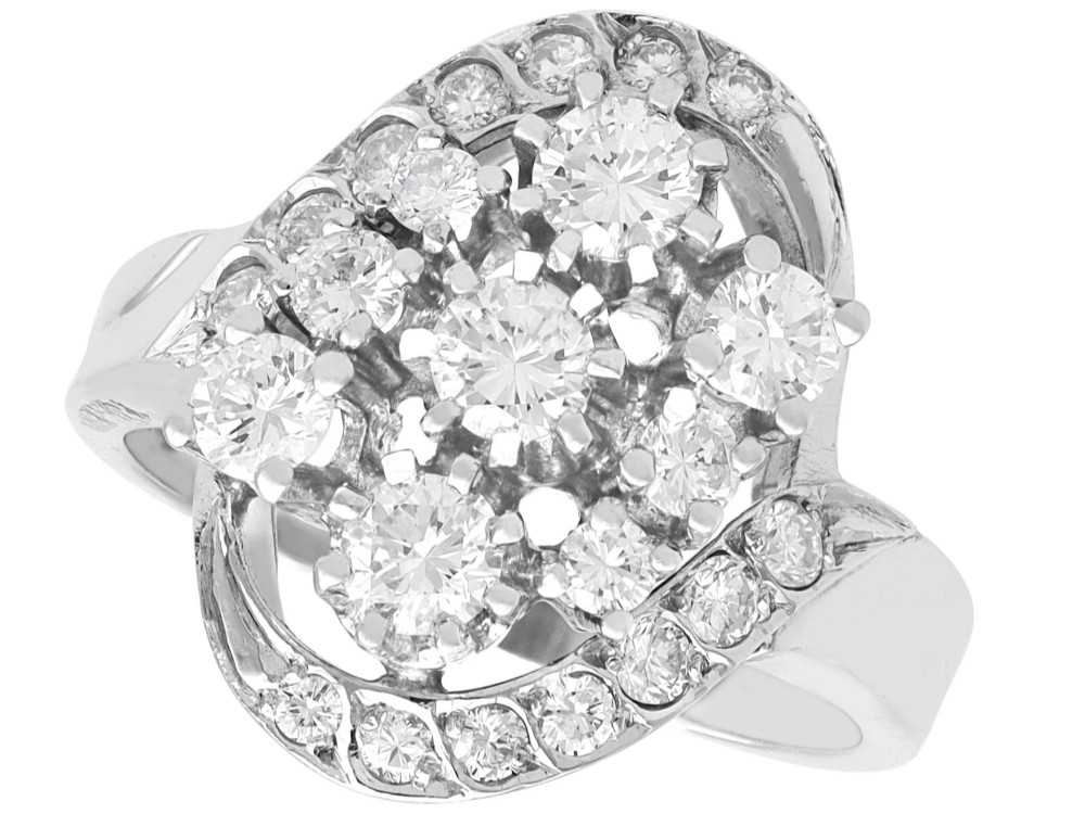 A vintage 1950s 14ct white gold dress ring featuring a multi-diamond cluster and curved accent bands.
