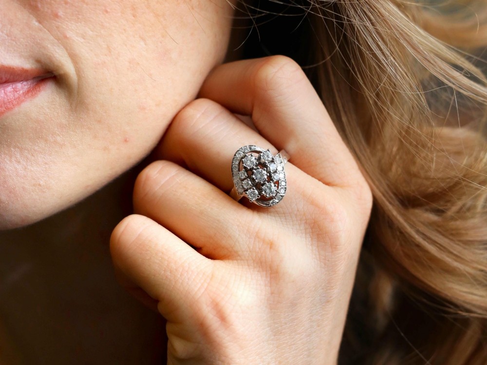 A vintage 1950s 14ct white gold dress ring featuring a multi-diamond cluster and curved accent bands. View III