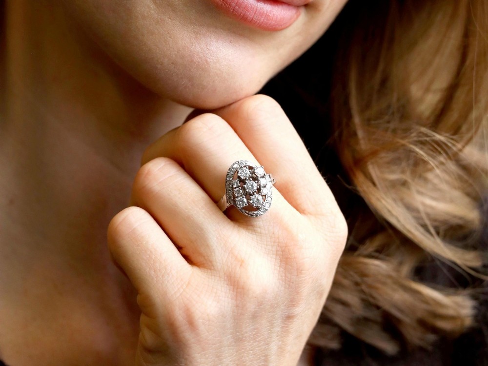 A vintage 1950s 14ct white gold dress ring featuring a multi-diamond cluster and curved accent bands. View IV