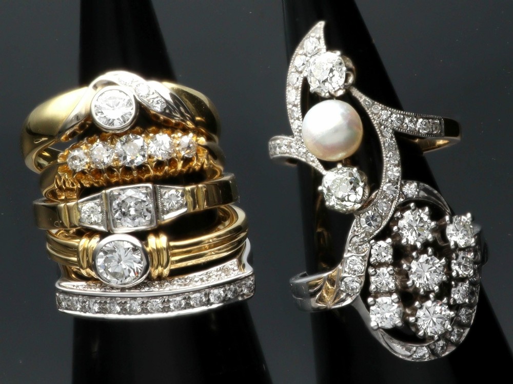 A vintage 1950s 14ct white gold dress ring featuring a multi-diamond cluster and curved accent bands. View V