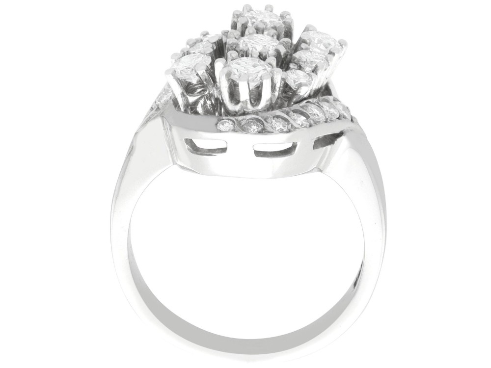 A vintage 1950s 14ct white gold dress ring featuring a multi-diamond cluster and curved accent bands. View VIII