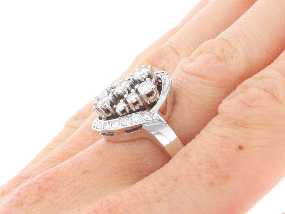 A vintage 1950s 14ct white gold dress ring featuring a multi-diamond cluster and curved accent bands. View XI