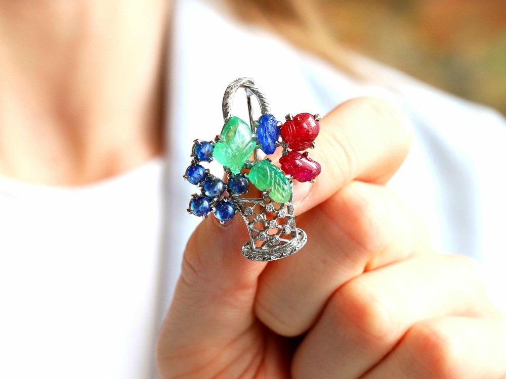An 18ct white gold Tutti Frutti basket brooch featuring carved emeralds, rubies, sapphire cabochons, and small diamonds. View III