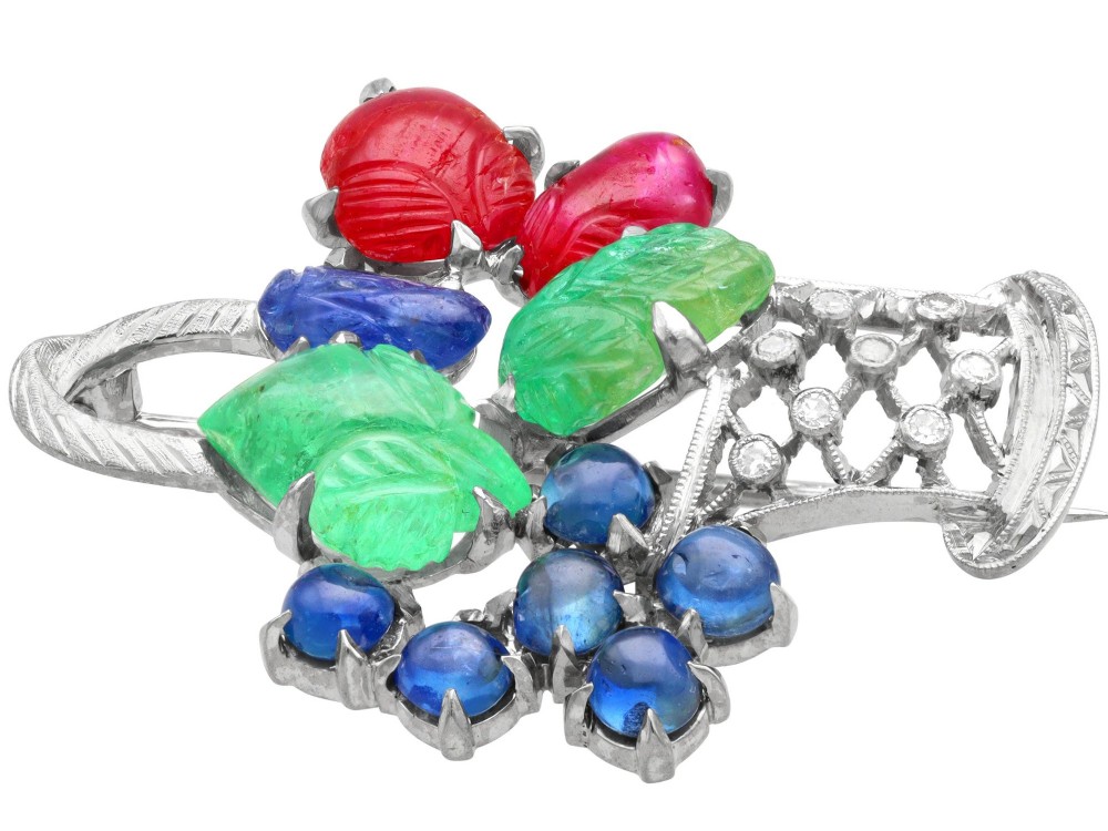 An 18ct white gold Tutti Frutti basket brooch featuring carved emeralds, rubies, sapphire cabochons, and small diamonds. View VII