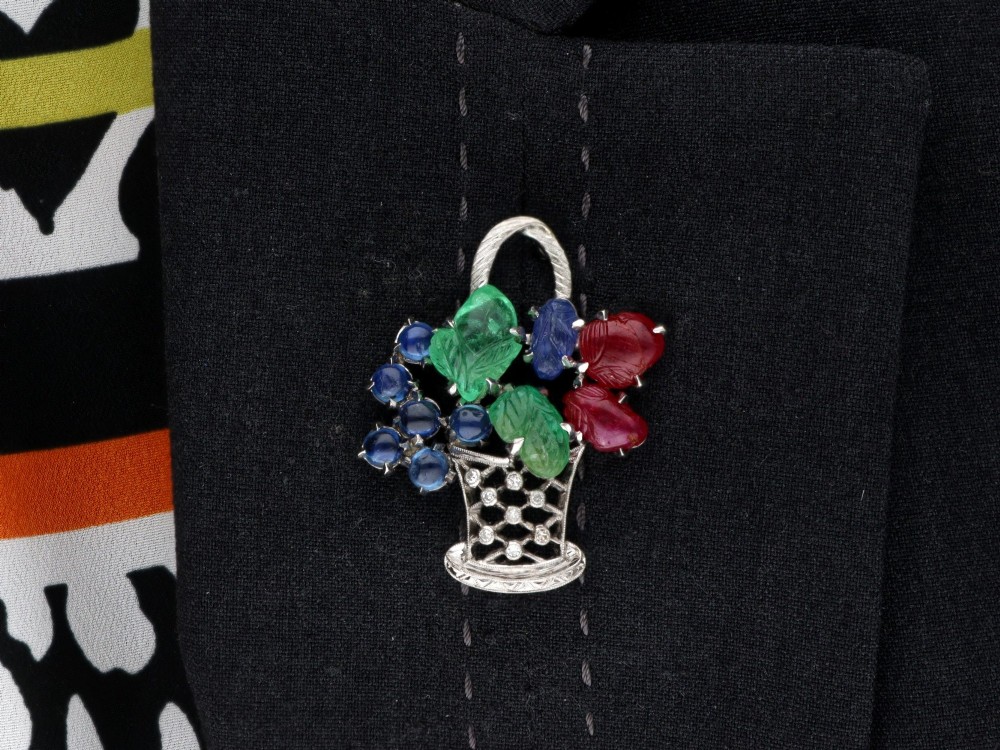 An 18ct white gold Tutti Frutti basket brooch featuring carved emeralds, rubies, sapphire cabochons, and small diamonds. View XIV