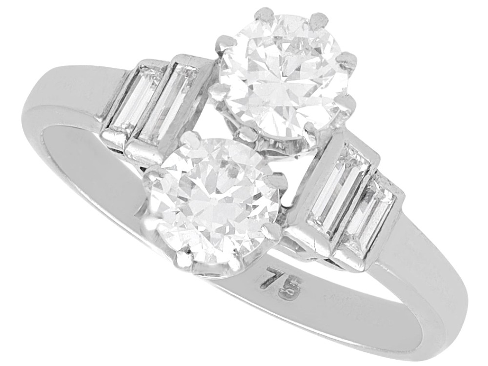 An Art Deco 18ct white gold two-stone diamond ring with stepped baguette cut diamond shoulders.
