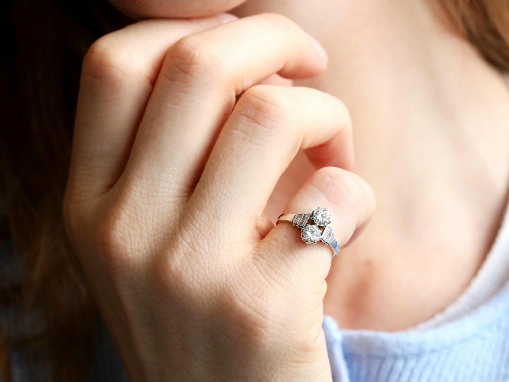 An Art Deco 18ct white gold two-stone diamond ring with stepped baguette cut diamond shoulders. View III