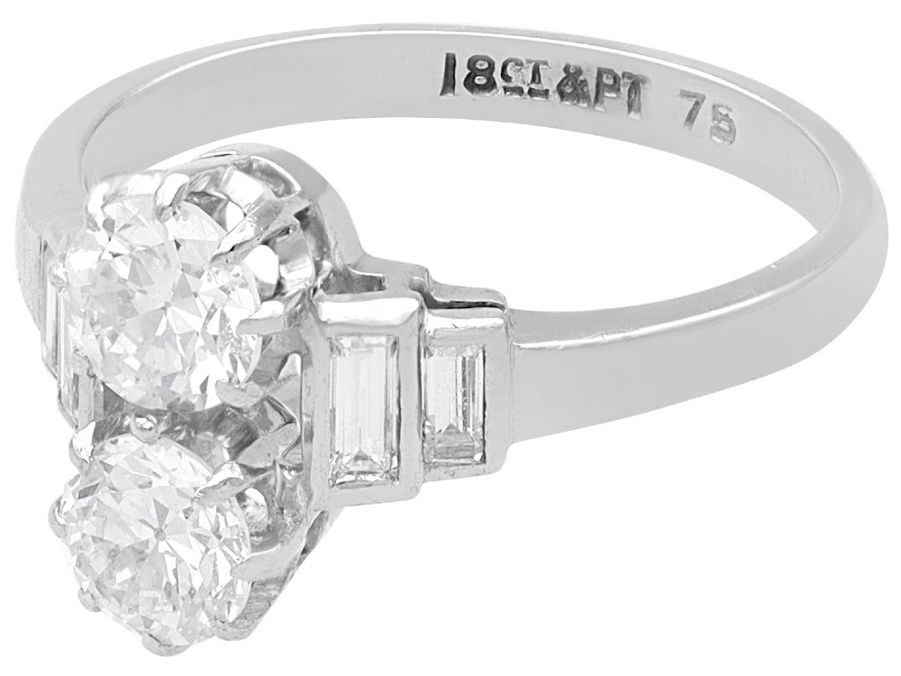 An Art Deco 18ct white gold two-stone diamond ring with stepped baguette cut diamond shoulders. View V