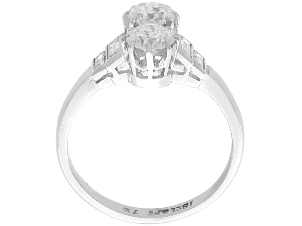 An Art Deco 18ct white gold two-stone diamond ring with stepped baguette cut diamond shoulders. View VII