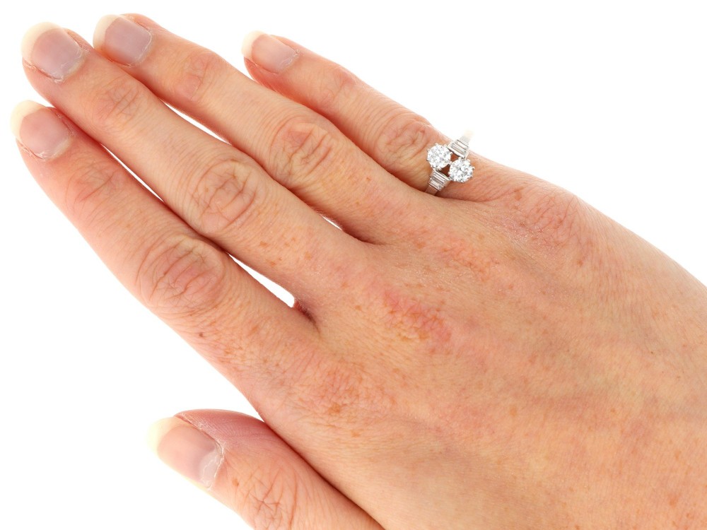 An Art Deco 18ct white gold two-stone diamond ring with stepped baguette cut diamond shoulders. View VIII