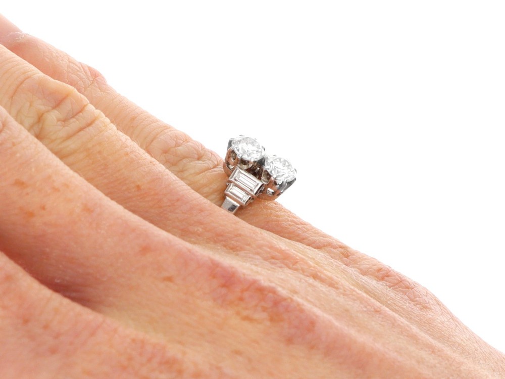 An Art Deco 18ct white gold two-stone diamond ring with stepped baguette cut diamond shoulders. View IX