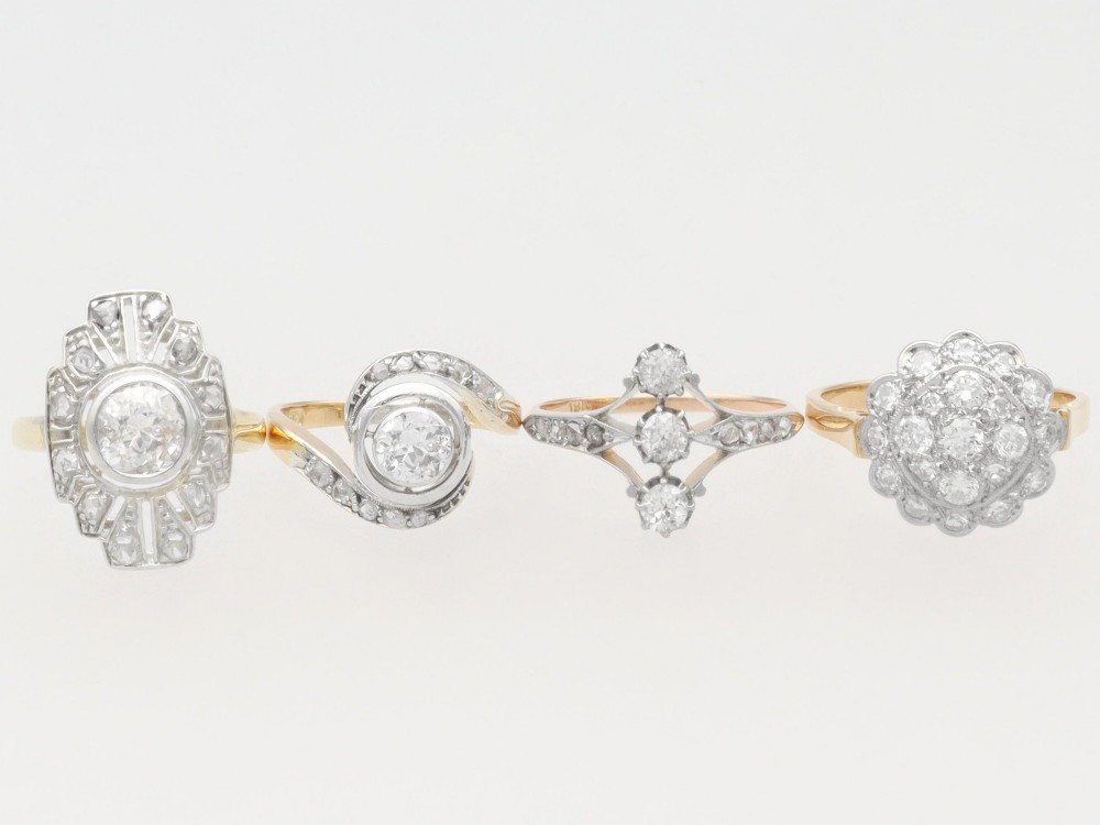 An antique 18ct yellow gold twist ring featuring a central round diamond set within a swooping platinum accent band set with smaller diamonds. View VII