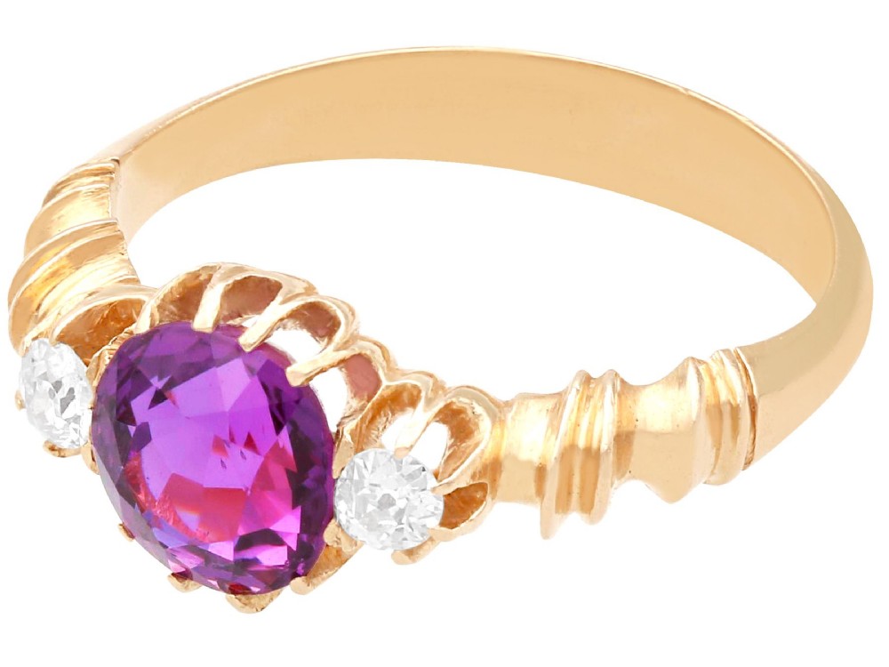 A Victorian 15ct rose gold trilogy ring set with a central purple sapphire flanked by two diamonds on carved shoulders. View VIII