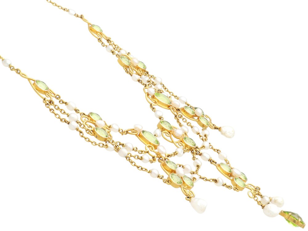 An 18ct yellow gold Belle Epoque festoon necklace featuring faceted green peridots, intricate scrollwork, and suspended natural pearl drops. View VIII
