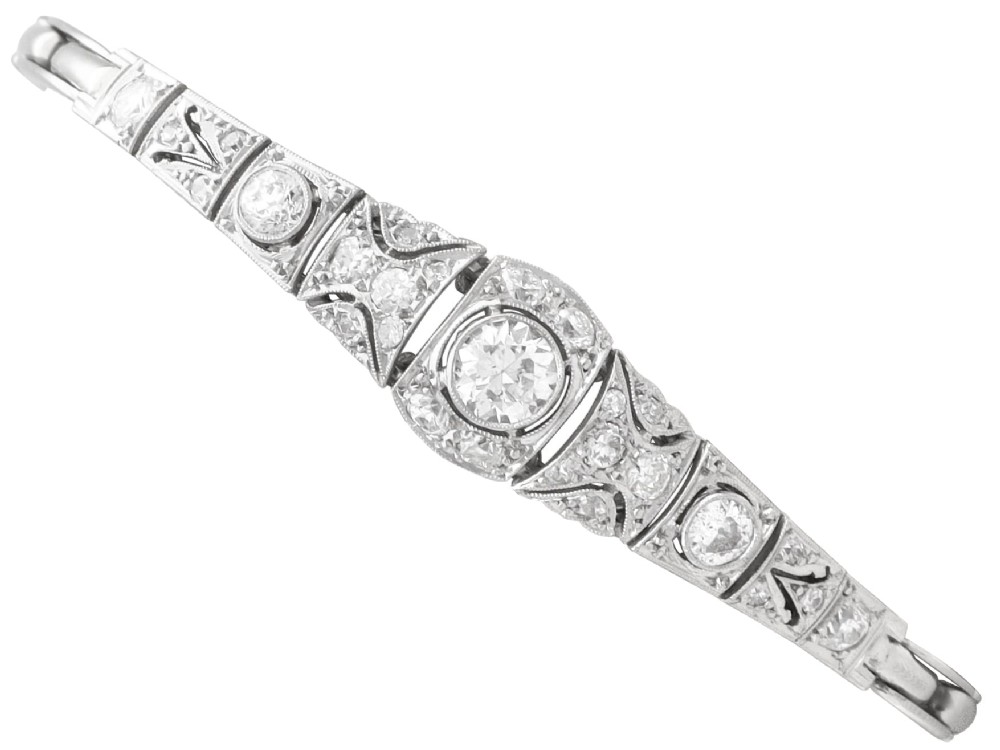 An Art Deco 18ct white gold bracelet featuring articulated geometric panels set with diamonds and finished with millegrain edging.