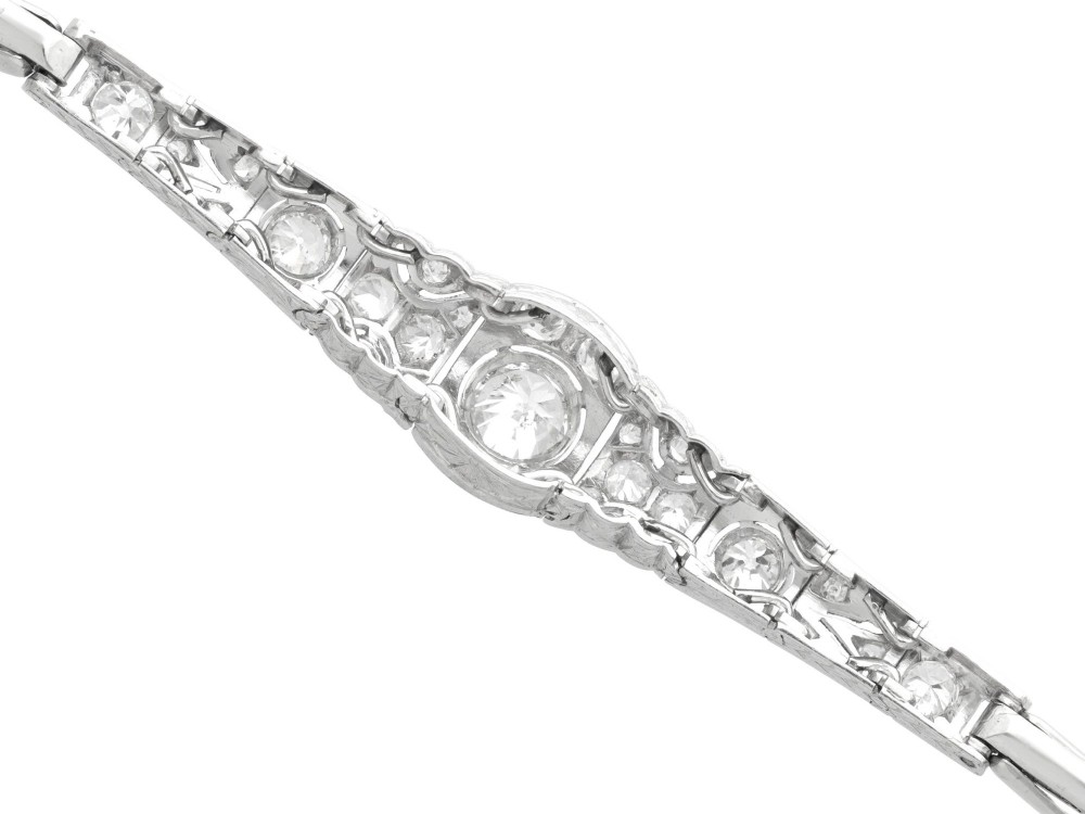 An Art Deco 18ct white gold bracelet featuring articulated geometric panels set with diamonds and finished with millegrain edging. View VIII