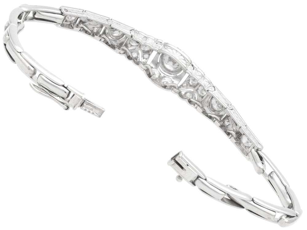 An Art Deco 18ct white gold bracelet featuring articulated geometric panels set with diamonds and finished with millegrain edging. View IX
