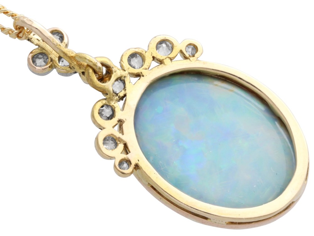 An Edwardian 9ct yellow gold pendant featuring an oval cabochon opal surmounted by millegrain-set diamonds. View XI