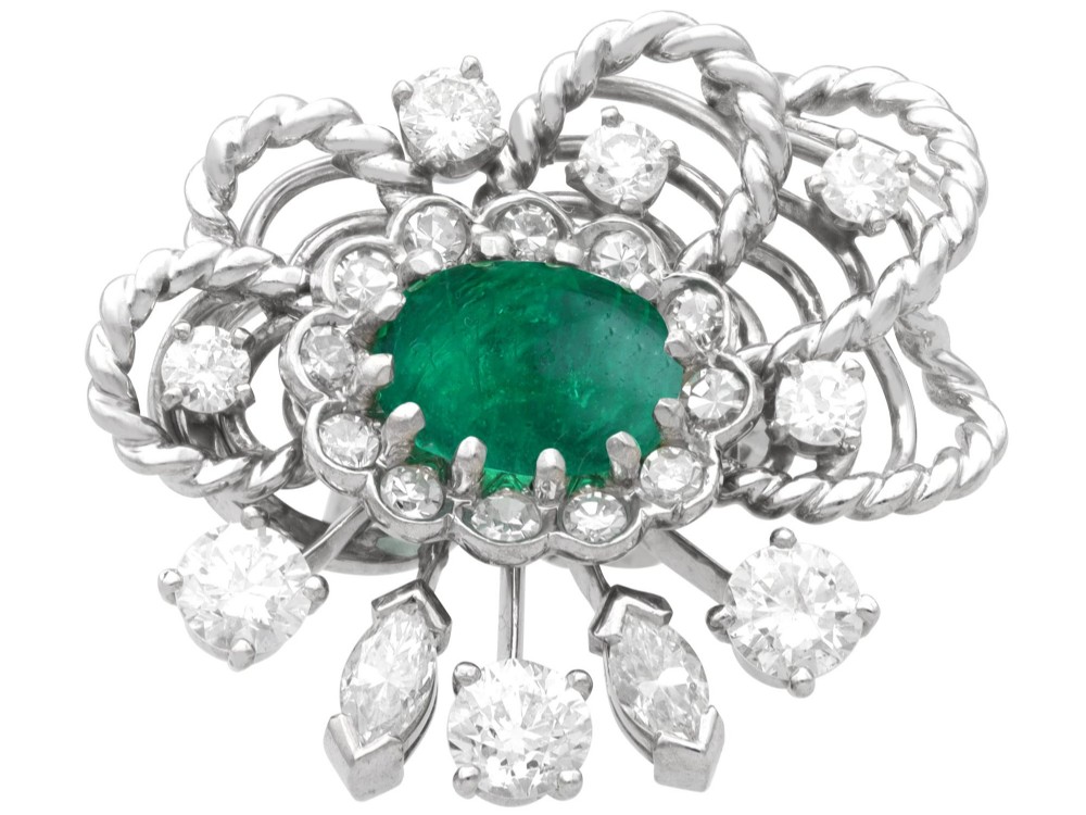 A pair of platinum and palladium clip earrings featuring oval central emeralds surrounded by brilliant-cut diamonds and rope-twist metalwork. View VI