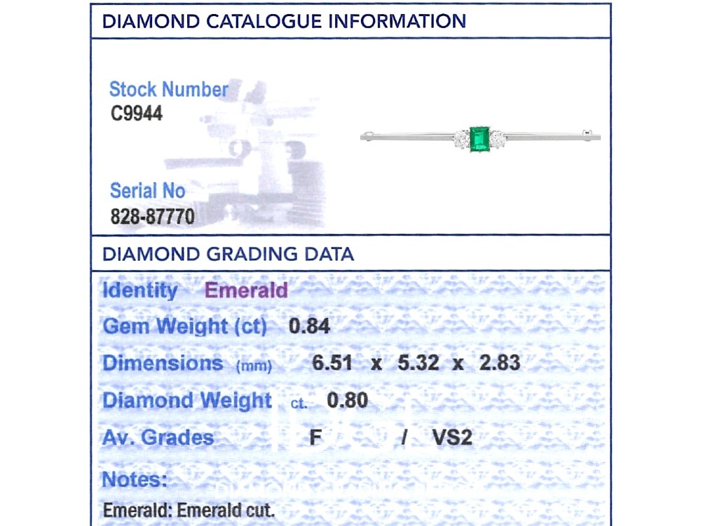 An antique 18ct white gold bar brooch featuring a central rectangular emerald cut emerald flanked by two round diamonds on a slender horizontal metal bar. View XI
