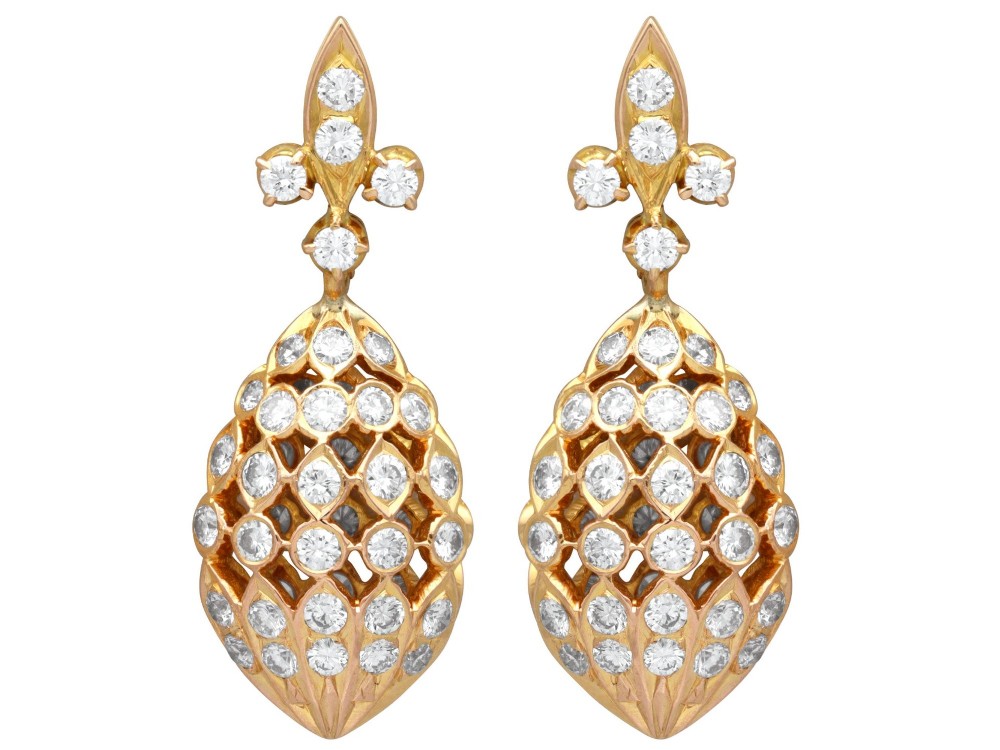 A pair of 18ct yellow gold drop earrings featuring fleur-de-lis surmounts above openwork teardrop cages set with round diamonds.