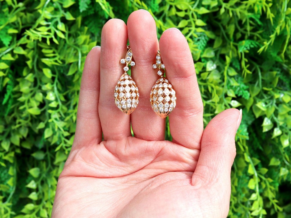 A pair of 18ct yellow gold drop earrings featuring fleur-de-lis surmounts above openwork teardrop cages set with round diamonds. View II