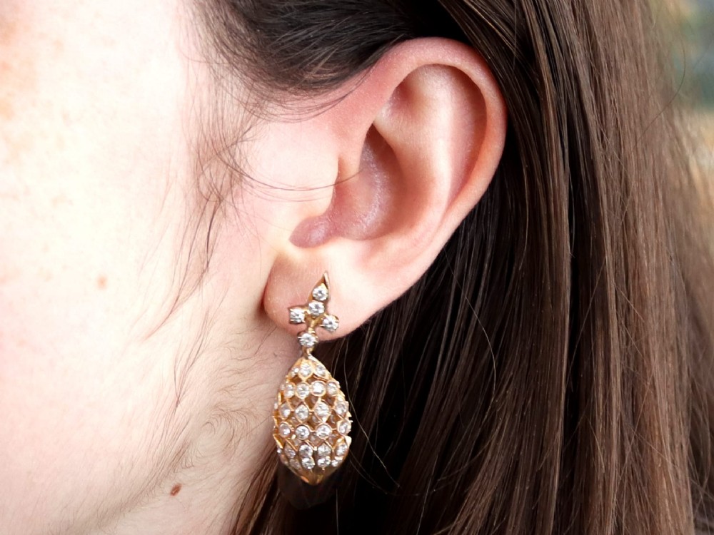 A pair of 18ct yellow gold drop earrings featuring fleur-de-lis surmounts above openwork teardrop cages set with round diamonds. View XII