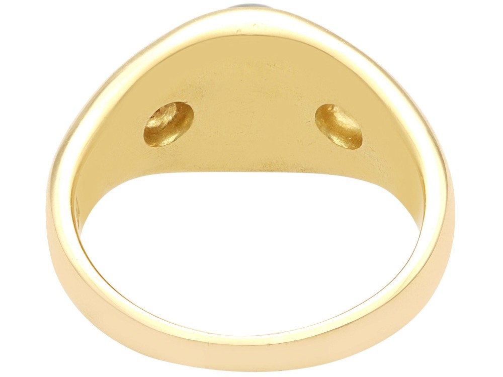 An 18ct yellow gold ring set with a central oval cabochon tigers eye stone flanked by two flush-set diamonds. View VI