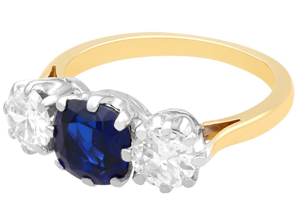 An antique 18ct yellow gold trilogy ring featuring a cushion-shaped blue sapphire flanked by two brilliant-cut diamonds in claw settings. View VIII