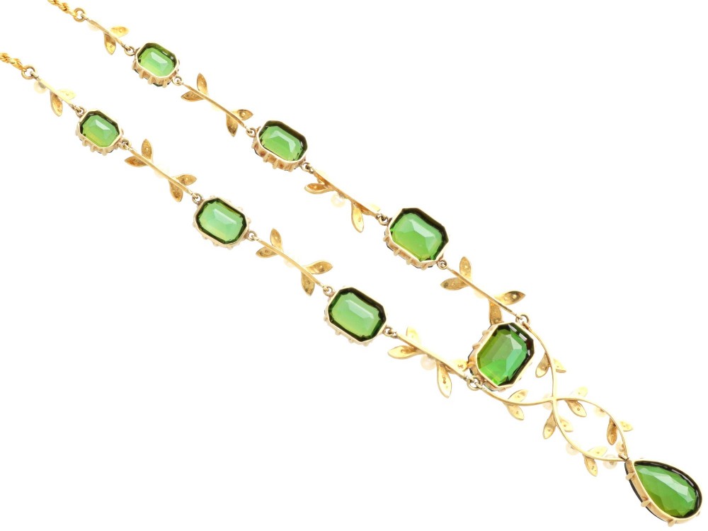 A late Victorian 14ct yellow gold necklace featuring emerald-cut green tourmalines connected by seed pearl foliate links and terminating in a pear-cut green tourmaline drop pendant. View XI