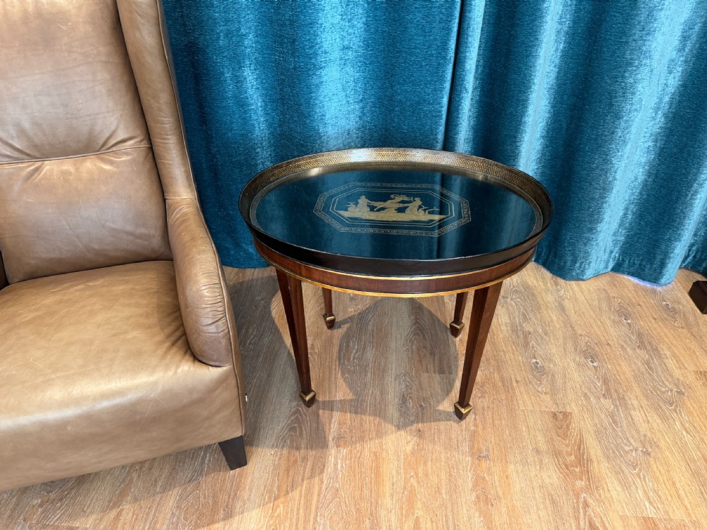 An early 19th-century oval tray table featuring a black lacquered top with gilded classical decoration on tapered mahogany legs. View IV
