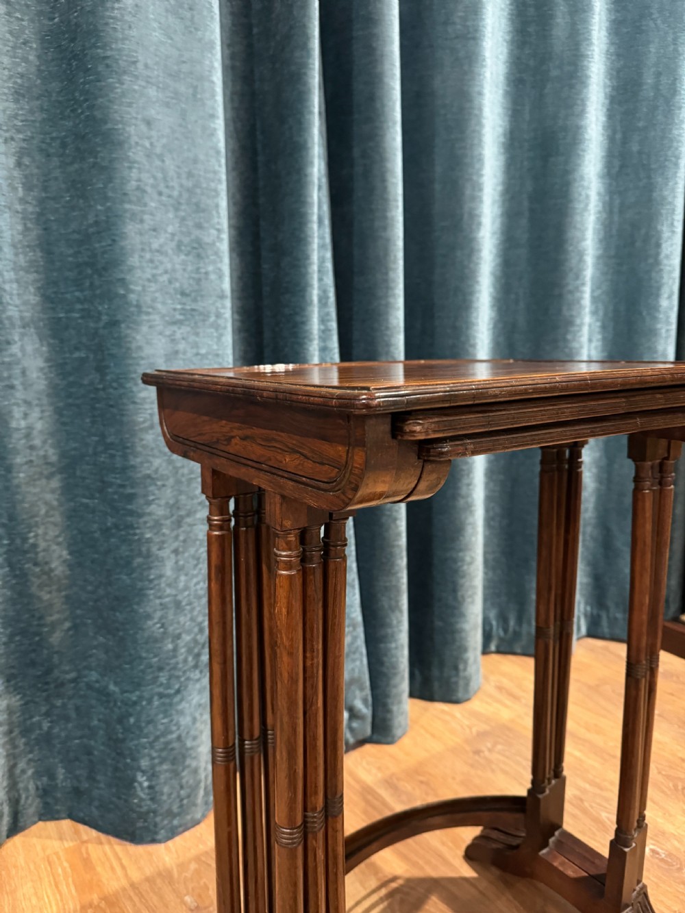 A set of three graduated Regency rosewood nesting side tables with slender turned legs and curved stretchers. View V