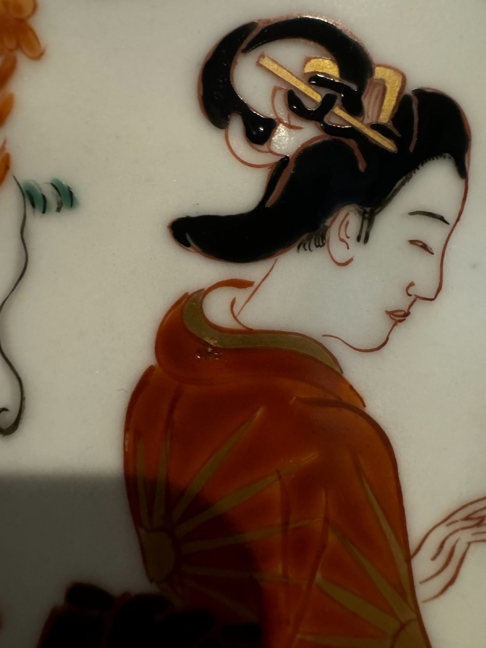 A large Japanese Meiji period porcelain charger plate with a scalloped edge, depicting women in traditional kimonos beneath a tree, bordered in cobalt blue and floral motifs. View V