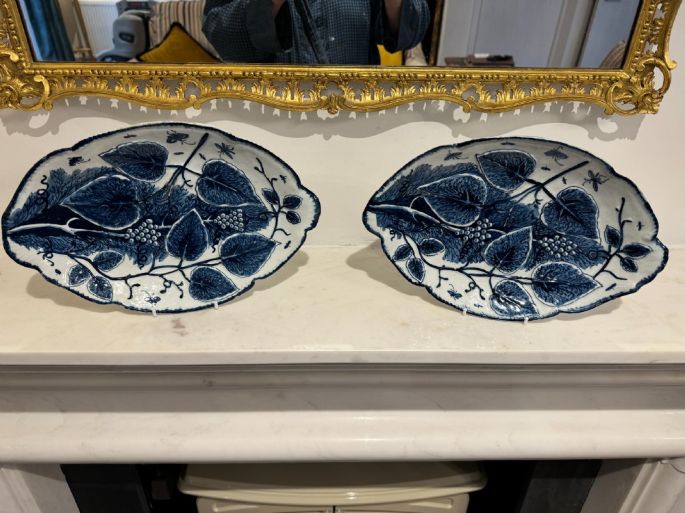 A pair of oval 18th-century English Bow porcelain serving dishes decorated with underglaze blue vine leaves, grapes, and insects.