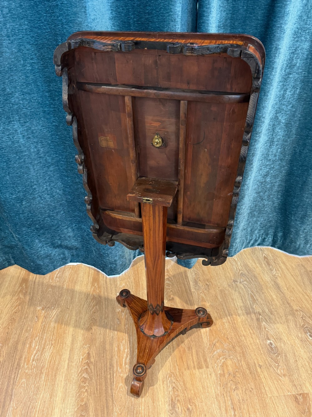 A Regency rosewood side table featuring a crossbanded rectangular top, a carved scrolled apron, and a central pedestal column supported by a triform base on scroll feet. View V