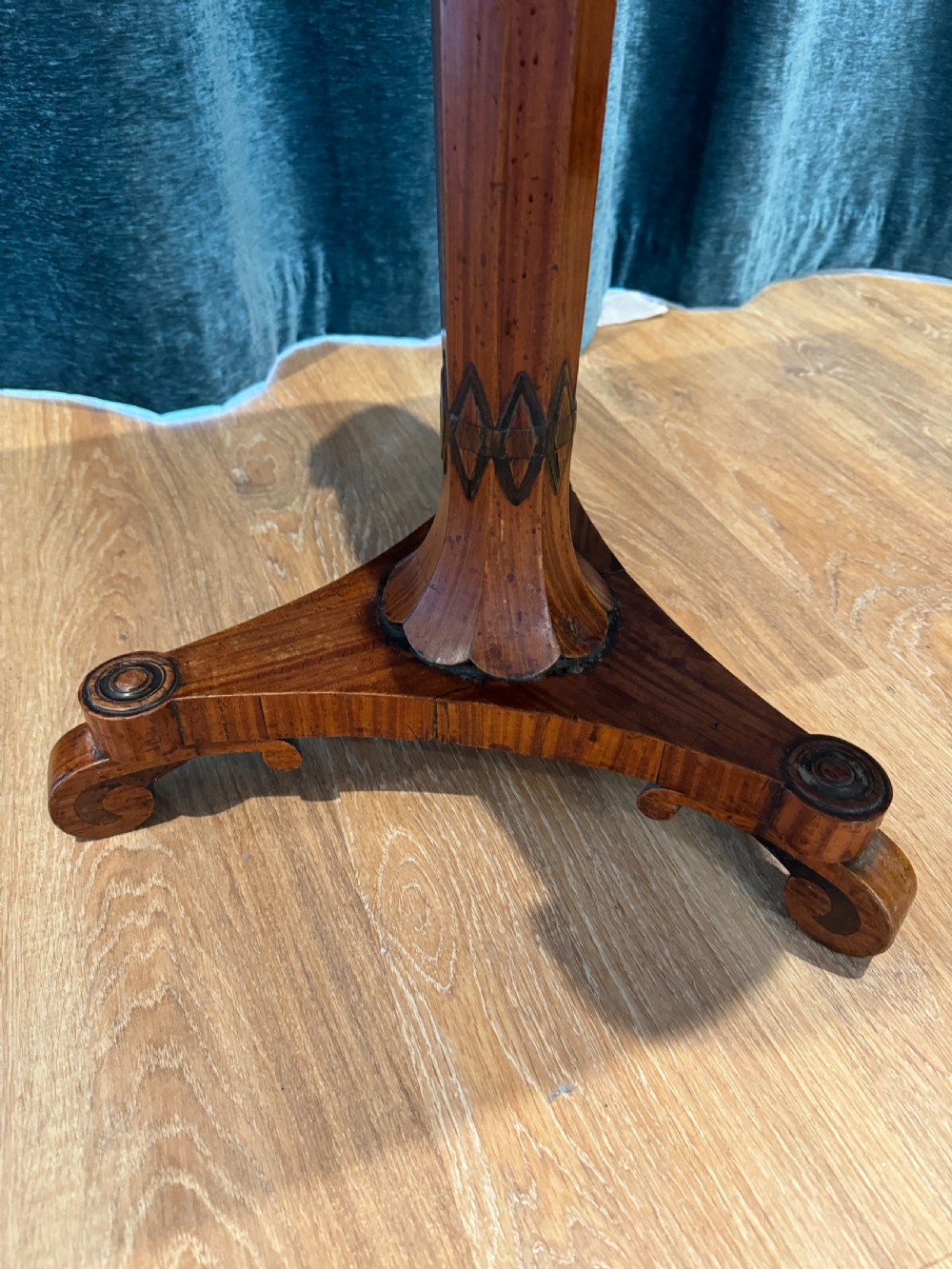 A Regency rosewood side table featuring a crossbanded rectangular top, a carved scrolled apron, and a central pedestal column supported by a triform base on scroll feet. View VI