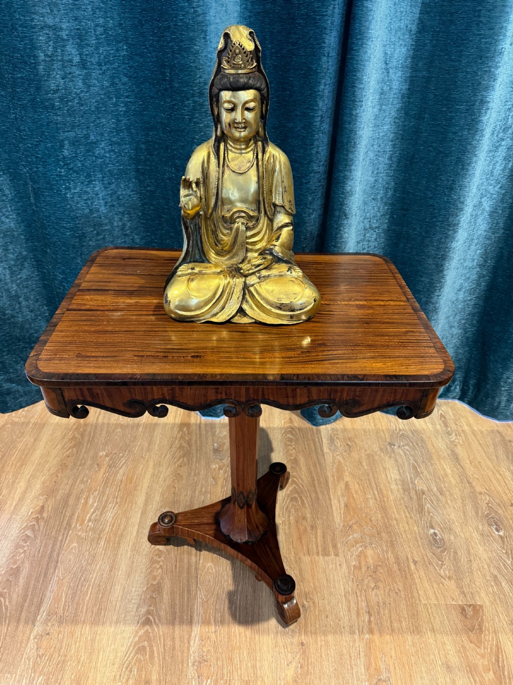 A Regency rosewood side table featuring a crossbanded rectangular top, a carved scrolled apron, and a central pedestal column supported by a triform base on scroll feet. View VIII