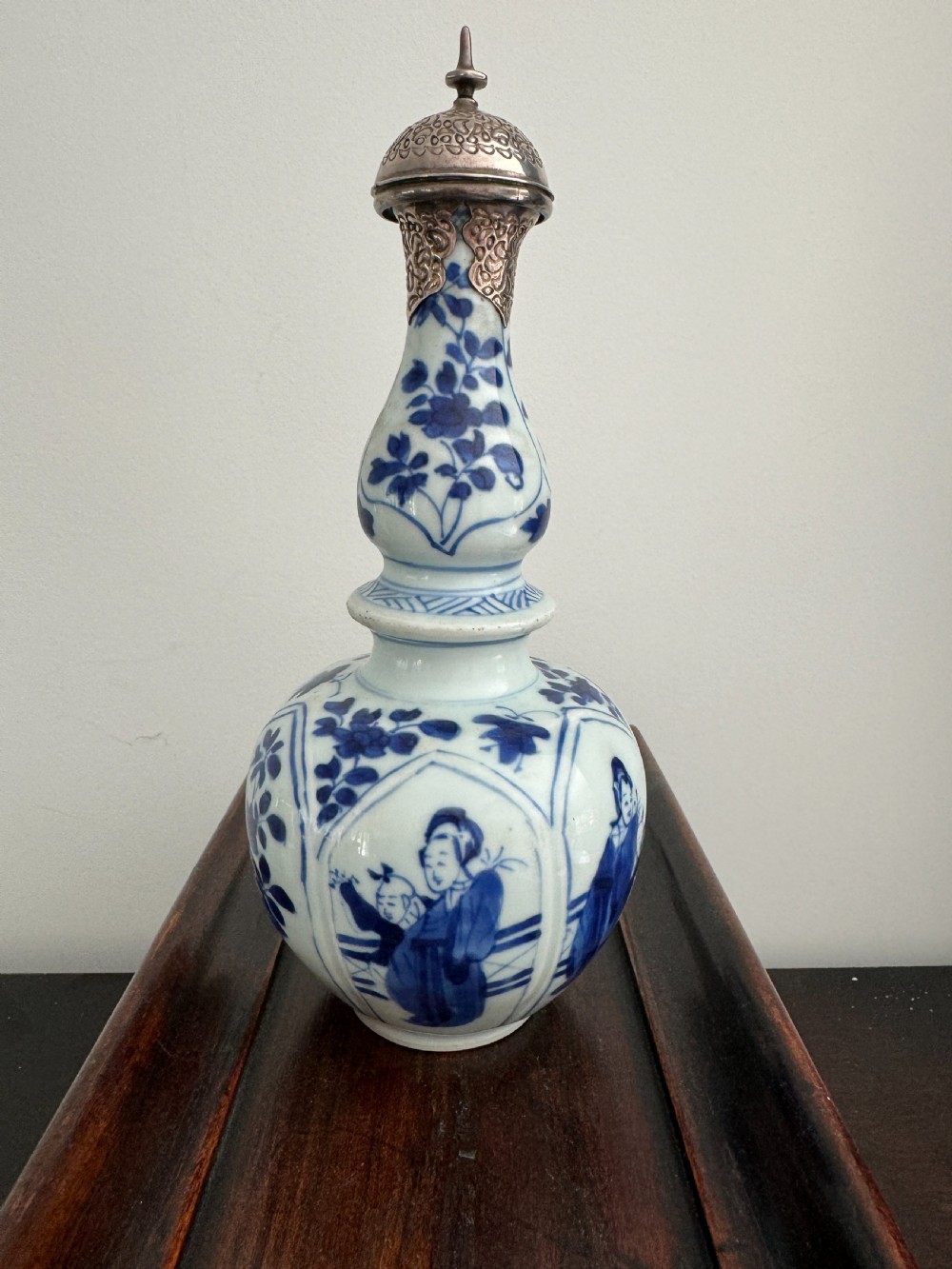 A Chinese Kangxi period underglaze blue and white porcelain vase decorated with figural panels and topped with an engraved silver Islamic mount.